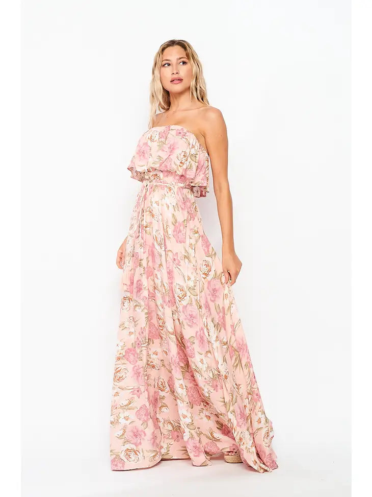 Featuring a layered/ruffled tube top design, a pink floral pattern, and a long/flowing maxi dress length.